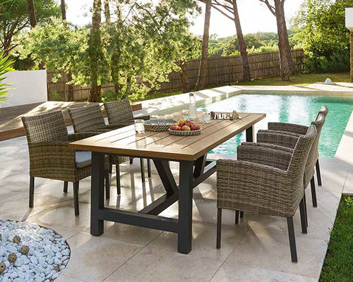 Table avec 6 fauteuils installés à côté d'une piscine