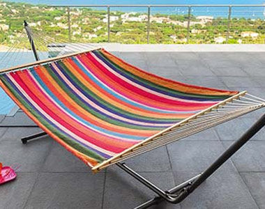 Hamac coloré rayé installé sur un support à hamac
