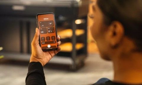 Smartphone avec l'application Wifire pour contrôler le barbecue Trager