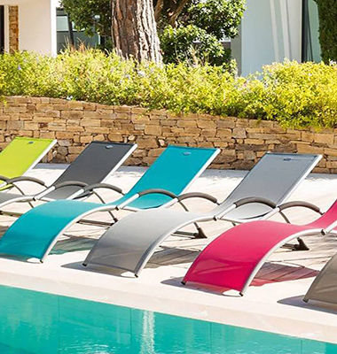 Transats colorés posés au bord d'une piscine