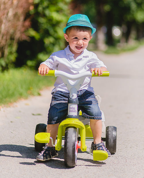 Enfant sur un tricycle vert et blanc