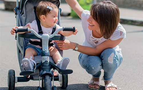 Jeune enfant dans un tricycle avec harnais de sécurité