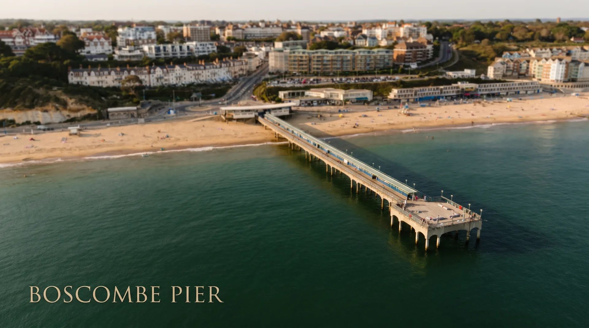 Aerial view of Boscombe Pier extending into the sea, sandy beach and buildings in the background