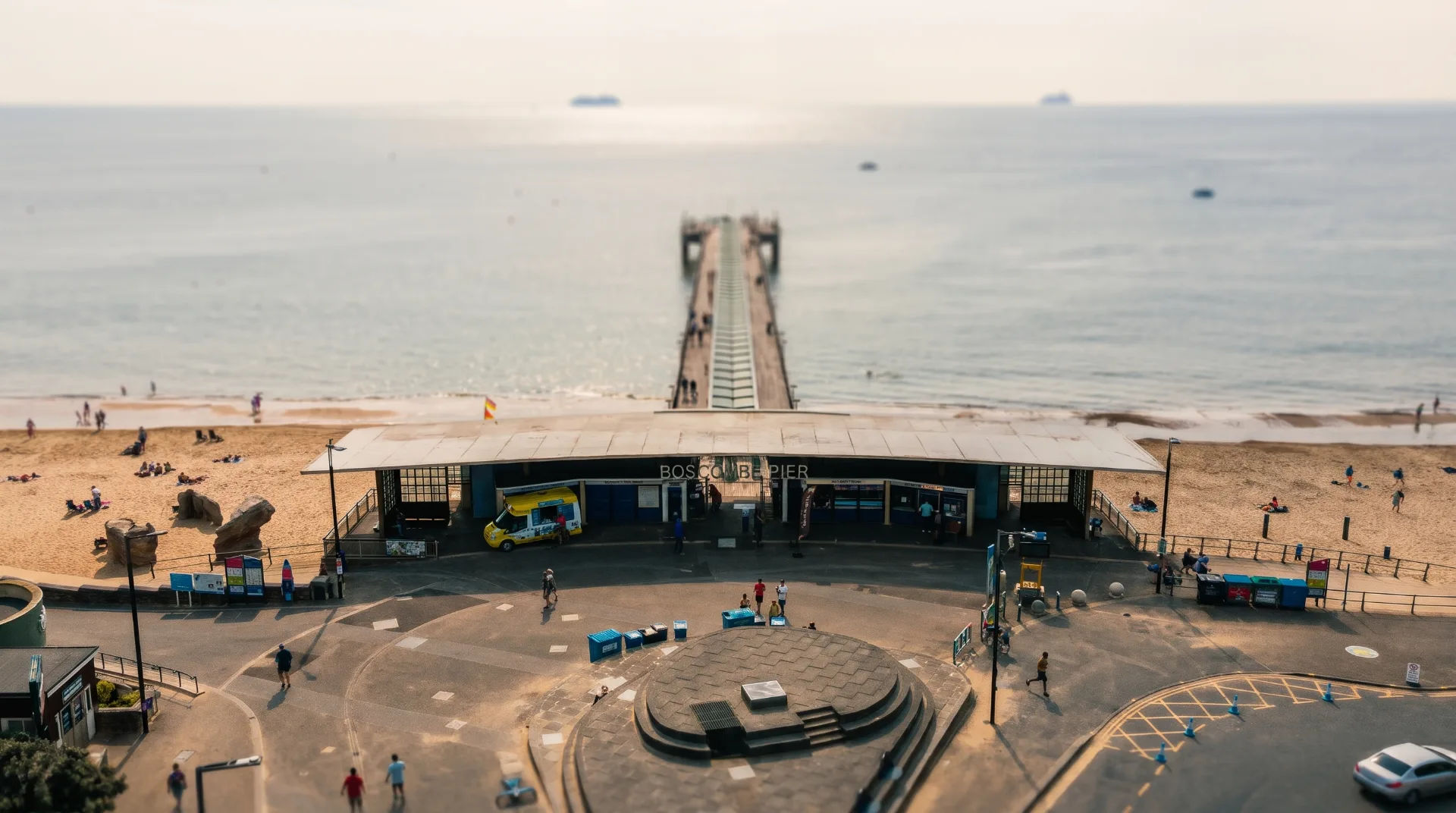 A view of Boscombe Beach with the pier in the background, beachgoers enjoying the sand, and facilities nearby.