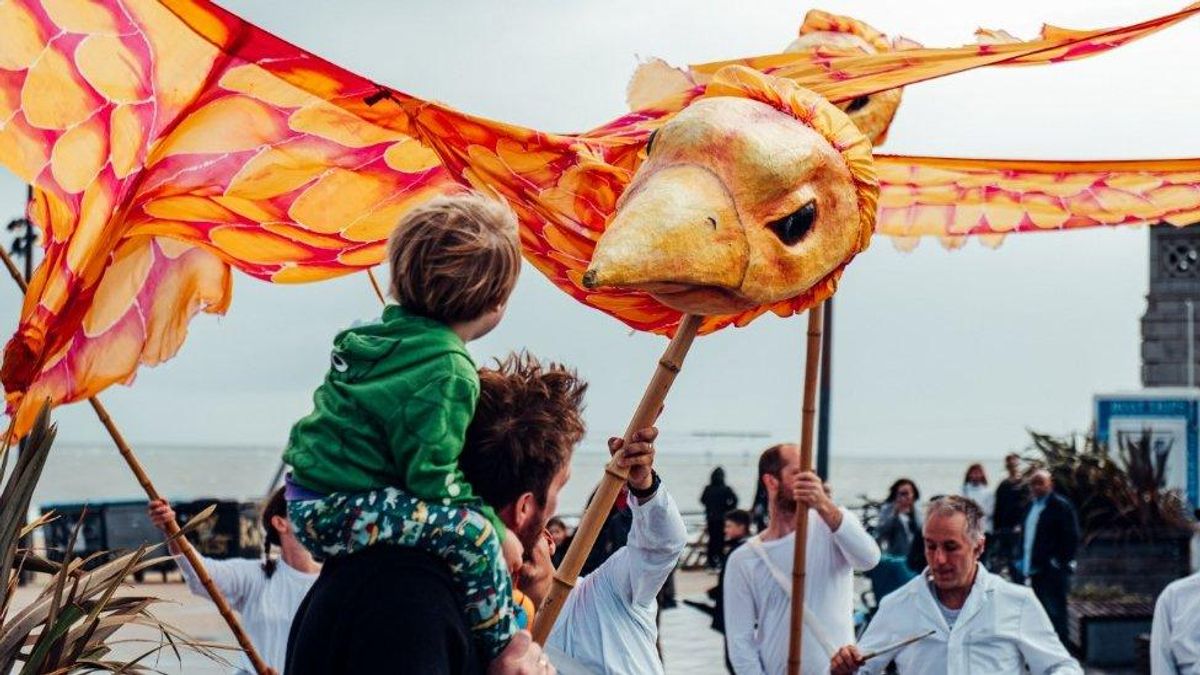 A giant orange puppet above the crowds in Bournemouth