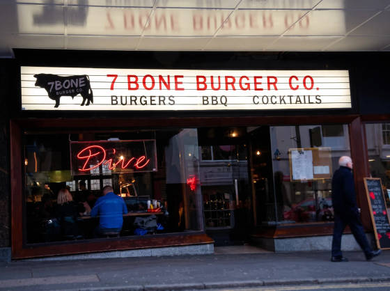 Exterior of 7 Bone Burger Co. with a neon 'Dive' sign