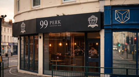 Exterior of 99 Perk cocktail bar with large windows and signage