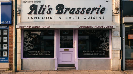 Front of Ali's Brasserie with signage for Indian cuisine