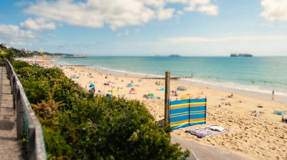 View of Bournemouth Beach with sunbathers and a beach screen