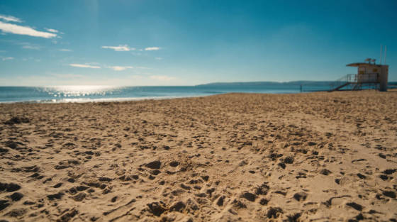 Sandy beach with a lifeguard station and the sea in the background