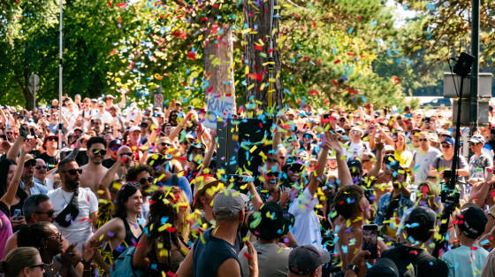 Crowd of people celebrating with colourful confetti in the air