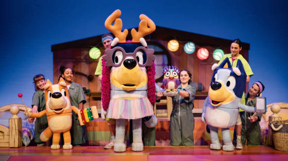 A colourful stage with animated dog characters and performers