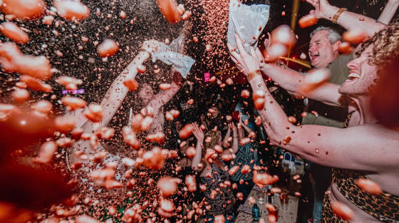 A lively party scene with confetti flying and people celebrating