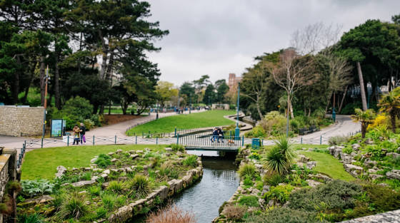 Landscaped gardens featuring a small bridge over a stream.