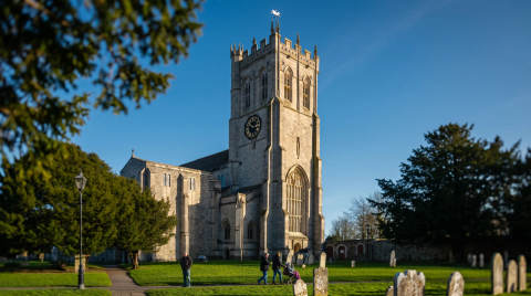 St. Peter's Church with a clock tower and gravestones in the foreground