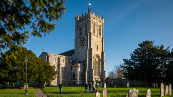 St. Peter's Church with a clock tower and gravestones in the foreground