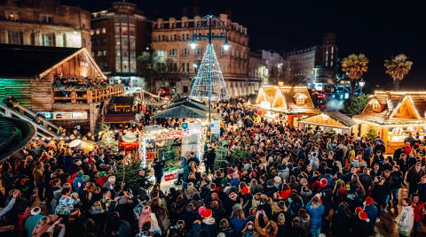 Crowd of people at Bournemouth Christmas Market with festive stalls