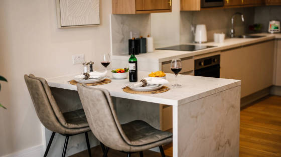 Stylish kitchen with a dining table set for two and wine