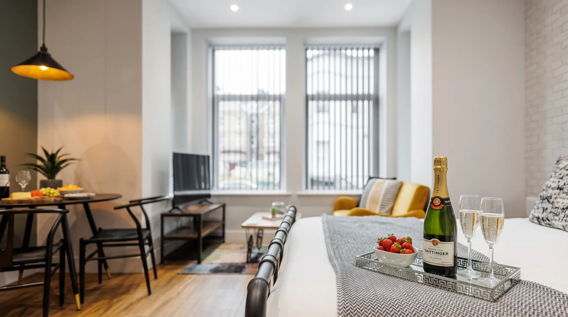 Stylish apartment interior featuring a dining table, champagne, strawberries, and a comfortable seating area