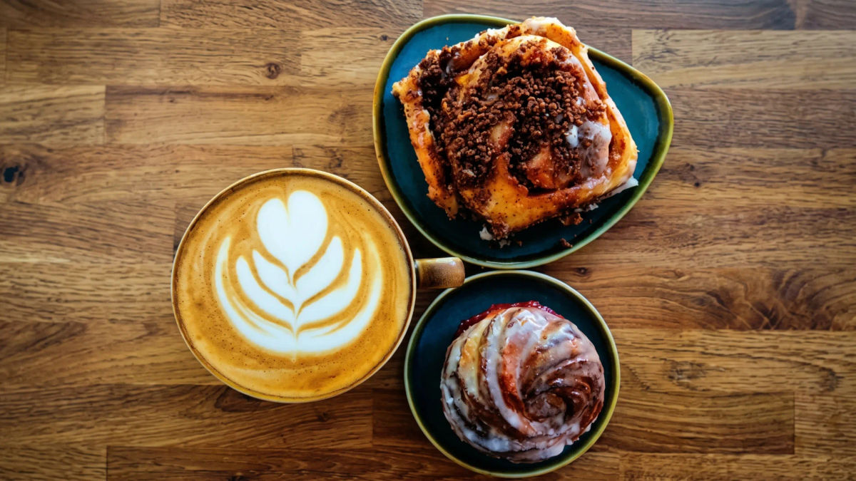 A flat white and pastries on a café table