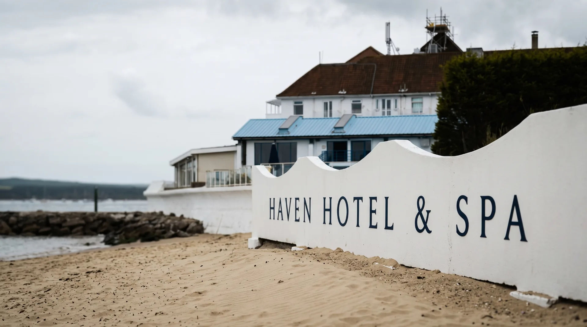 Close-up of the Haven Hotel sign on the beach with the hotel building in the background
