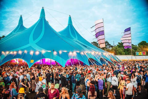 Large crowd gathered outside a blue festival tent