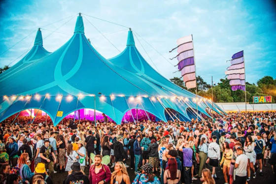 Large crowd gathered outside a blue festival tent