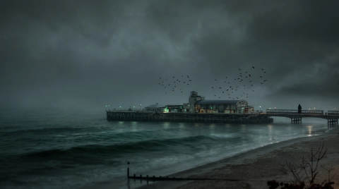 Bournemouth Pier under dark clouds with waves and birds