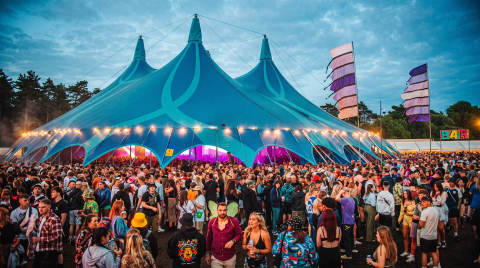 Large blue festival tent filled with a crowd of people
