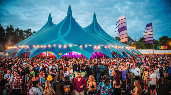 Large blue festival tent filled with a crowd of people