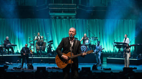 Musician with guitar performing on stage with a band