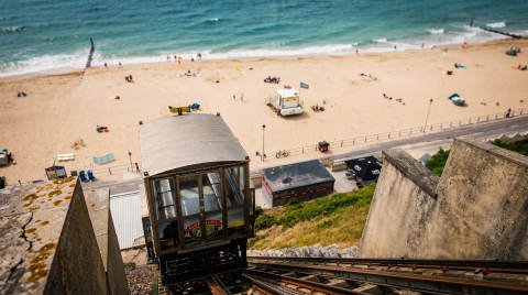 Cliff lift descending towards Bournemouth beach with people on the sand