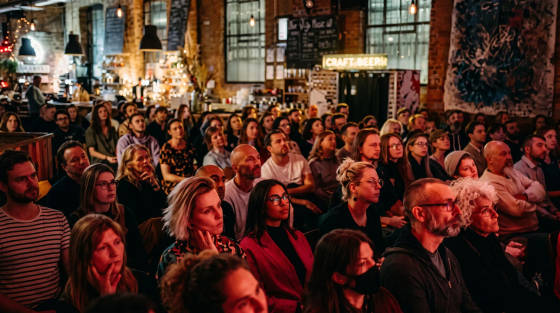 A diverse crowd of people seated in a lively indoor venue