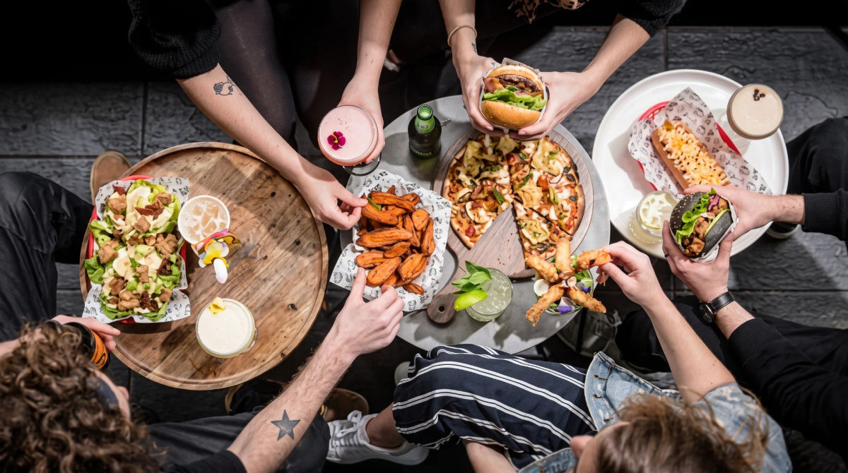 Friends sharing plates of food around a restaurant table