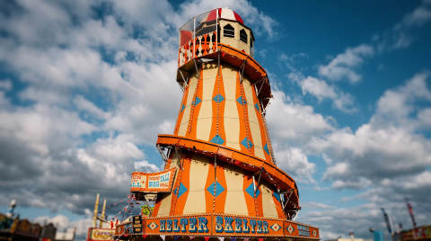 Colourful helter skelter ride against a cloudy sky