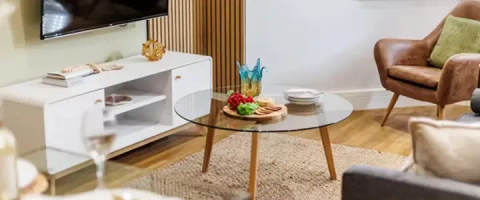 Living room with a glass coffee table, snacks, and a TV