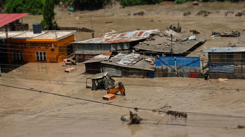 Flooded area with submerged buildings and an excavator