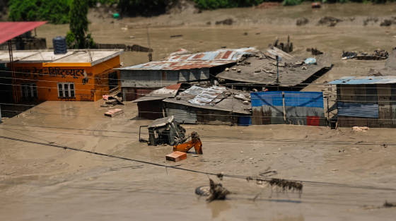 Flooded area with submerged buildings and an excavator
