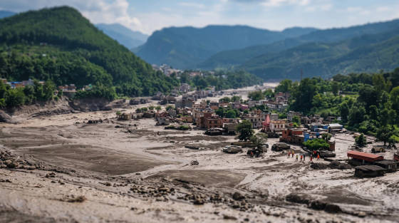 A village surrounded by mountains with recovery workers in the foreground