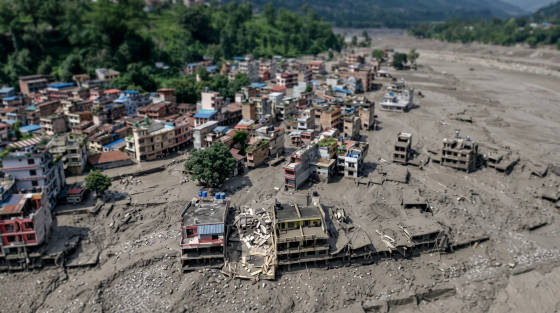 Buildings partially buried in mud with surrounding structures visible