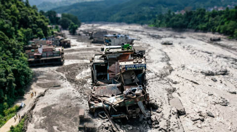 Abandoned Dada Cafe and vehicles in a dry riverbed