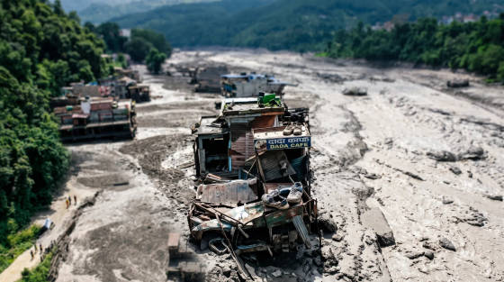 Abandoned Dada Cafe and vehicles in a dry riverbed