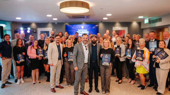 A large group of people holding awards at a ceremony