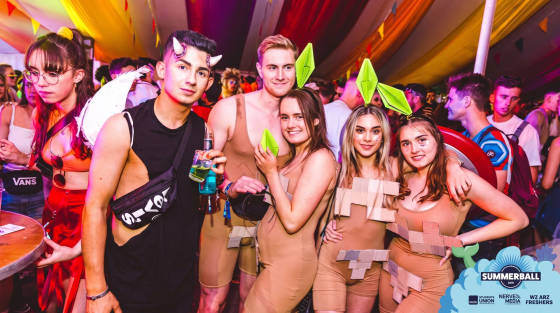 Group of students in fancy dress at a party with colourful decorations