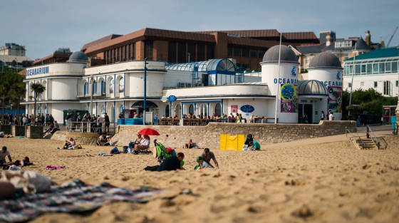 People relaxing on the sand in front of the Oceanarium