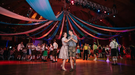 A couple dancing in traditional attire under decorated lights