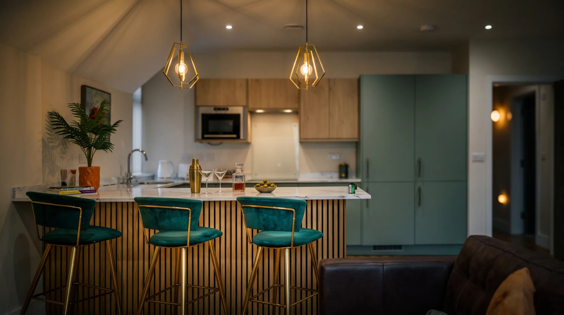 Modern kitchen with teal bar stools, marble countertop, and stylish lighting in a Bournemouth apartment