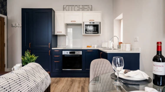 Stylish kitchen with navy cabinets and dining table