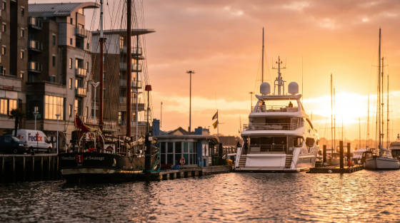Sunset view of yachts in Poole Harbour with buildings in the background