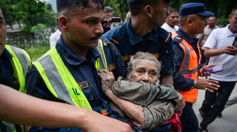 Elderly woman being carried by rescue workers in uniform